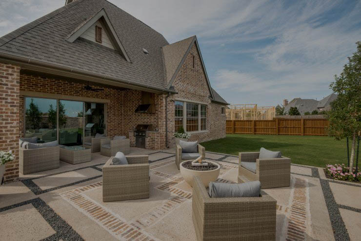 Outdoor furniture around fireplace outside of a house designed by Cambridge Homes