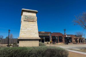 Large Rowlett sign on vertical brick structure in front of Rowlett commercial area